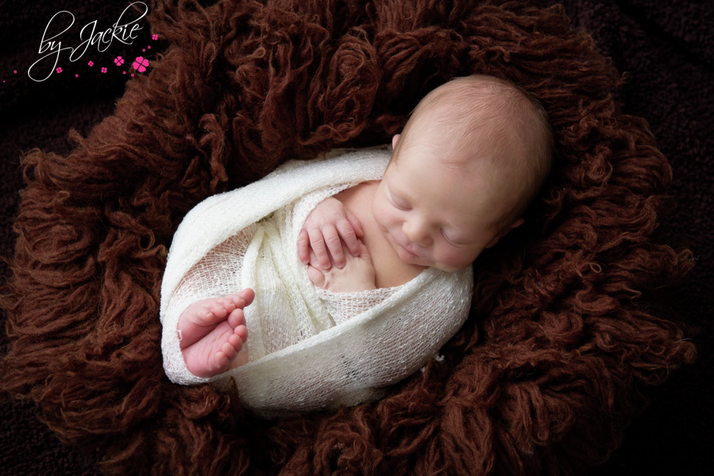 Photo of newborn baby, swaddled in cosy wrap. Photo By Jackie Photography in Selby