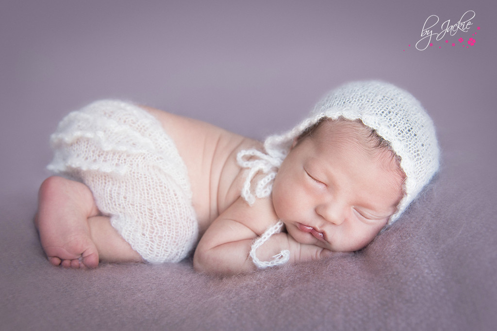 Photo of newborn baby girl asleep on her tummy in Hull. Image copyright By Jackie Photography, Selby and York