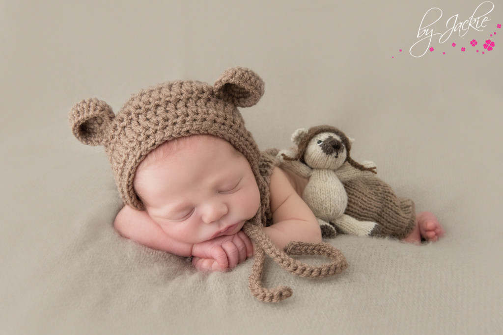 Photo of newborn baby boy wearing hat with ears and snuggling his hand-made teddy bear. Image copyright By Jackie Photography, Hemingbrough between Selby and York